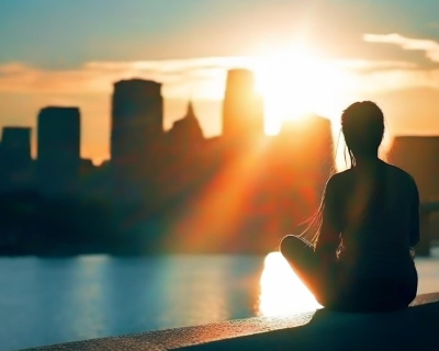 A woman sitting on the water at sunrise