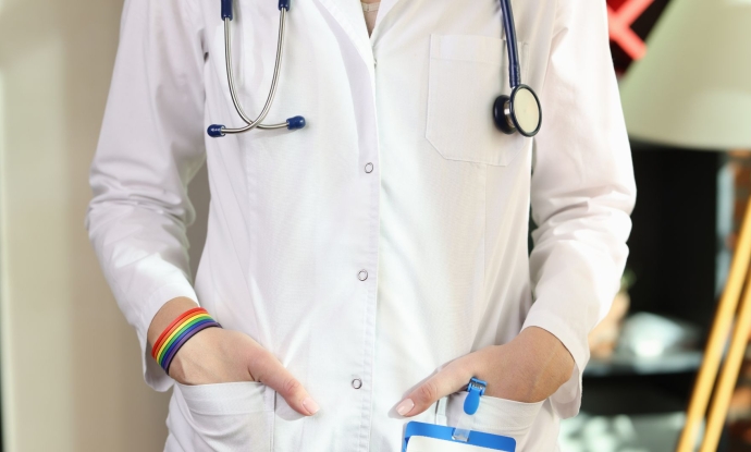 A doctor in a white lab coat wearing a rainbow bracelet